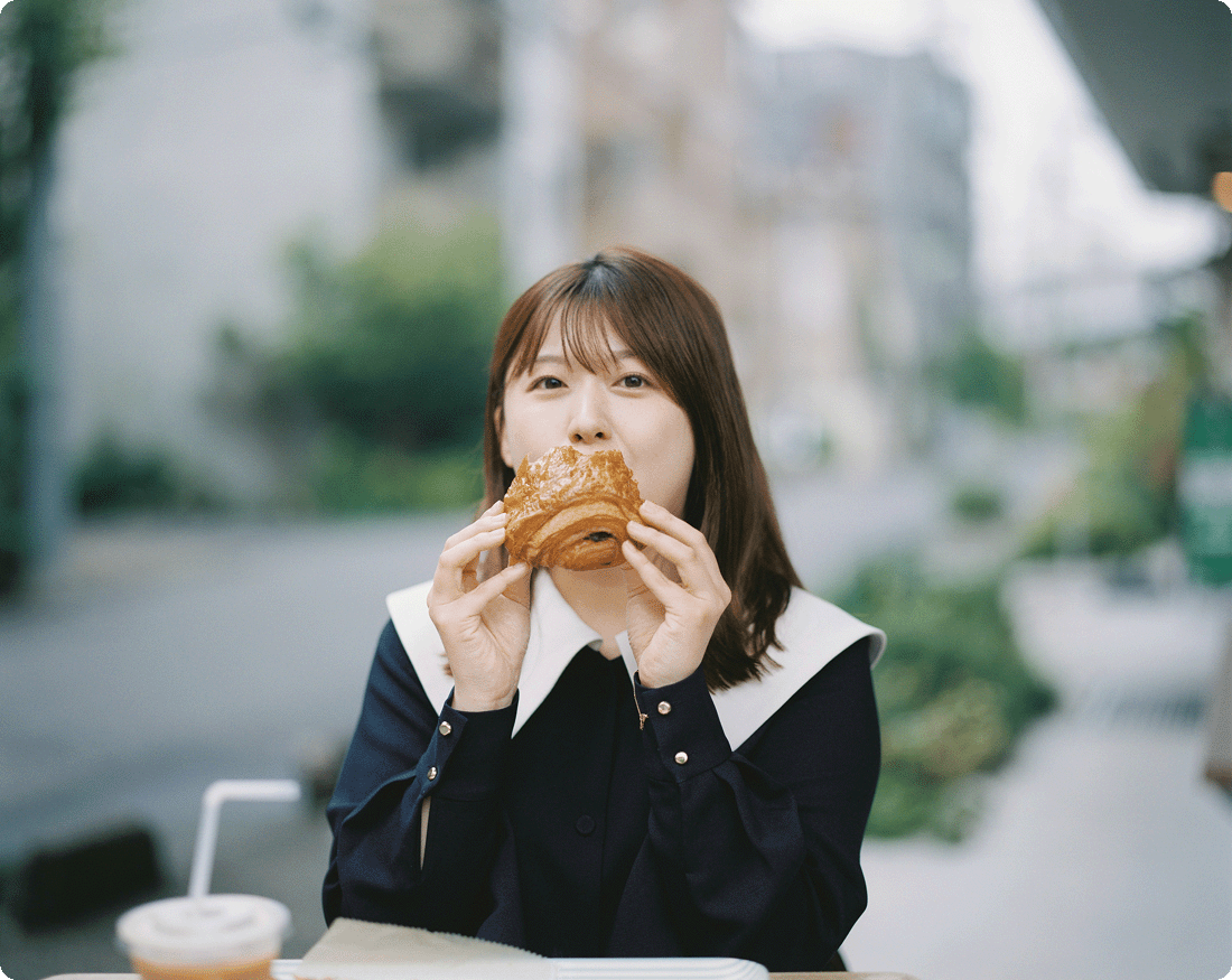 屋外でパンを食べる尾崎里紗のポートレート