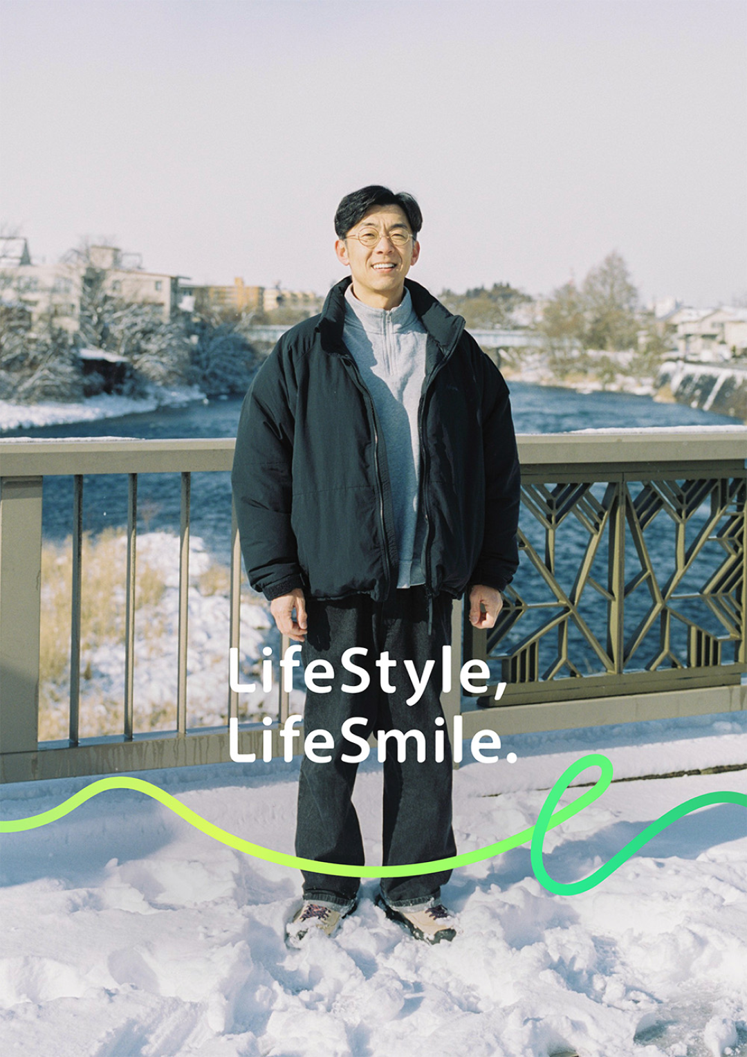 雪景色の川沿いの橋に立つ天津木村卓寛のポートレート