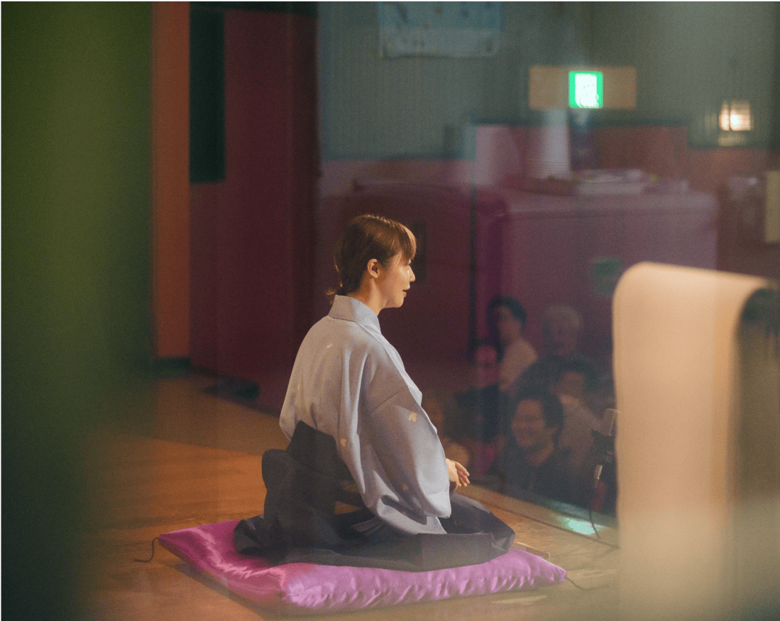 座布団に座り寄席をする女性