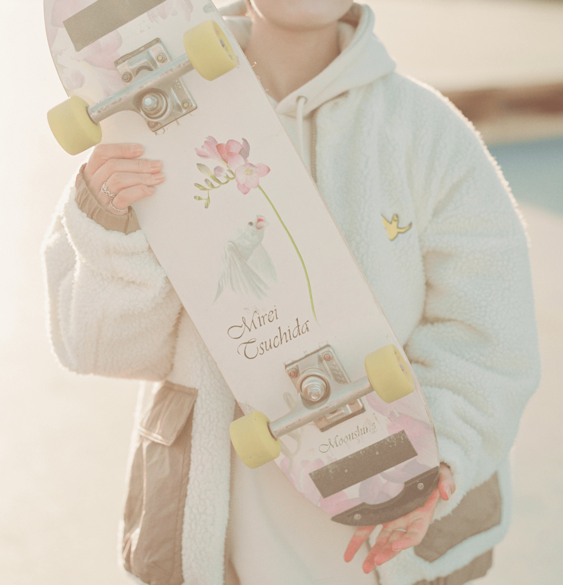 スケートボードを持っている様子。背面が見えている。