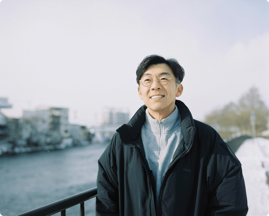 屋外で微笑む天津木村卓寛のバストアップ写真