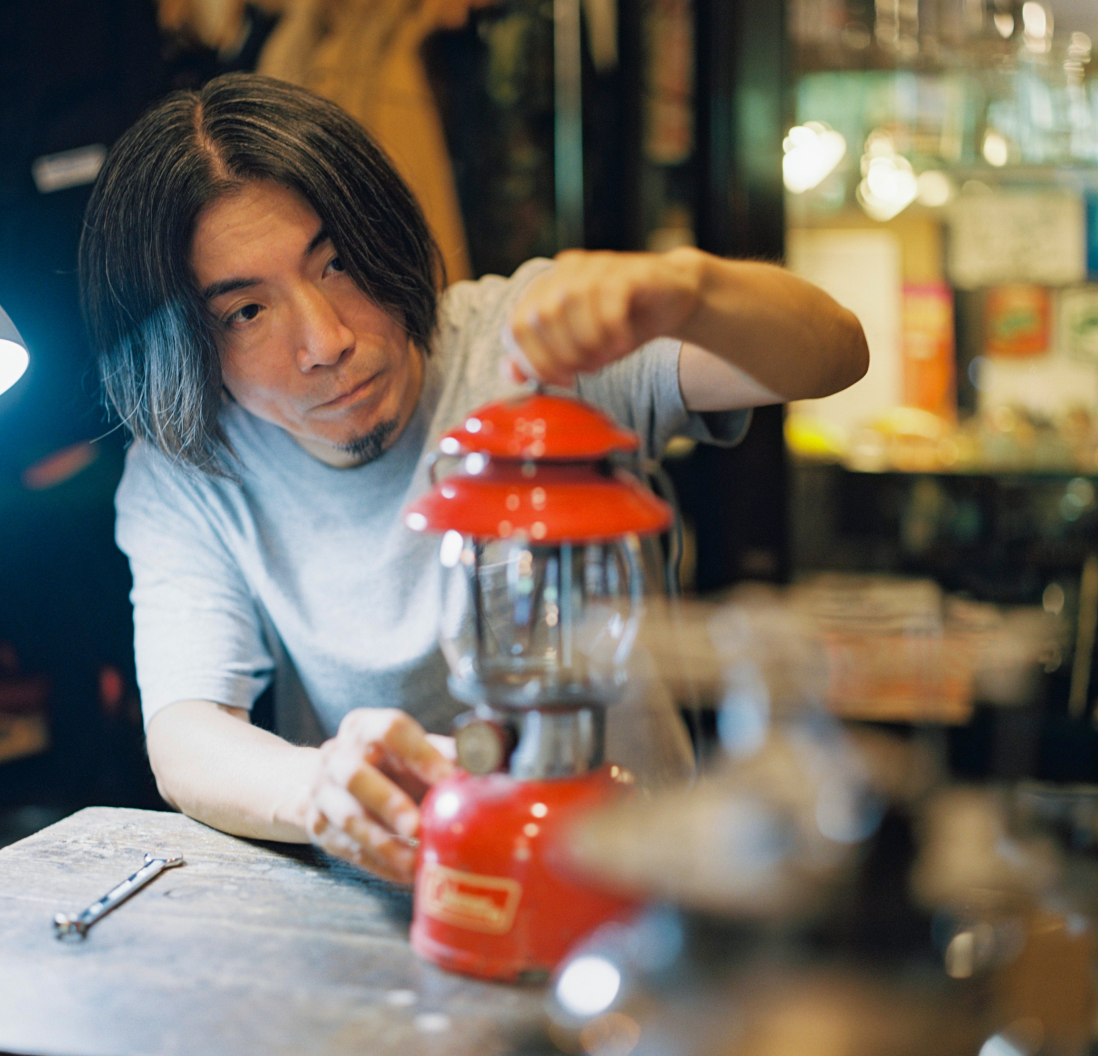 ヴィンテージランタンをメンテナンスしている男性。