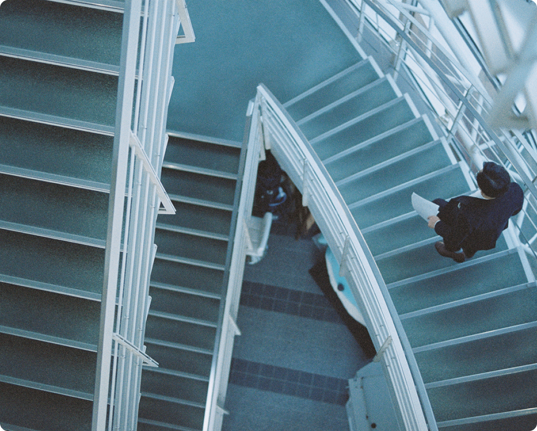 屋内階段を駆け降りる天津木村卓寛