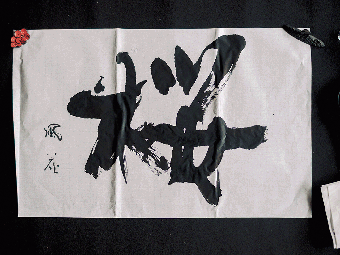 力強い筆文字が書かれた作品のクローズアップ。
