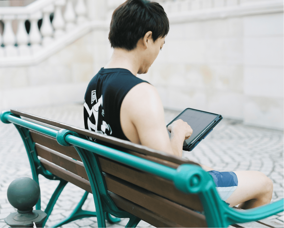 おばたのお兄さん ベンチでタブレットを見る様子