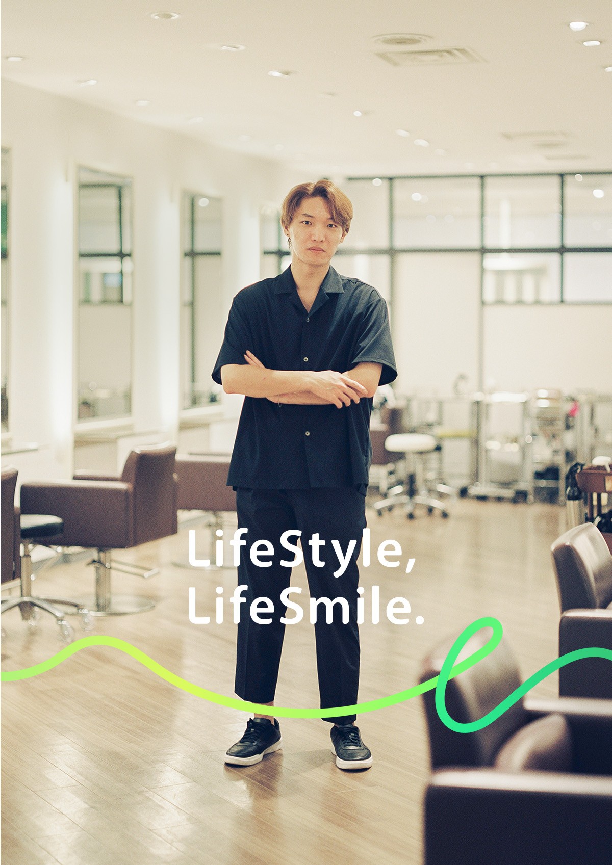 美容師 中高下 由真が腕を組んで正面を向いている写真。