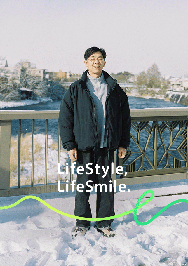 雪景色の川沿いの橋に立つ天津木村卓寛のポートレート