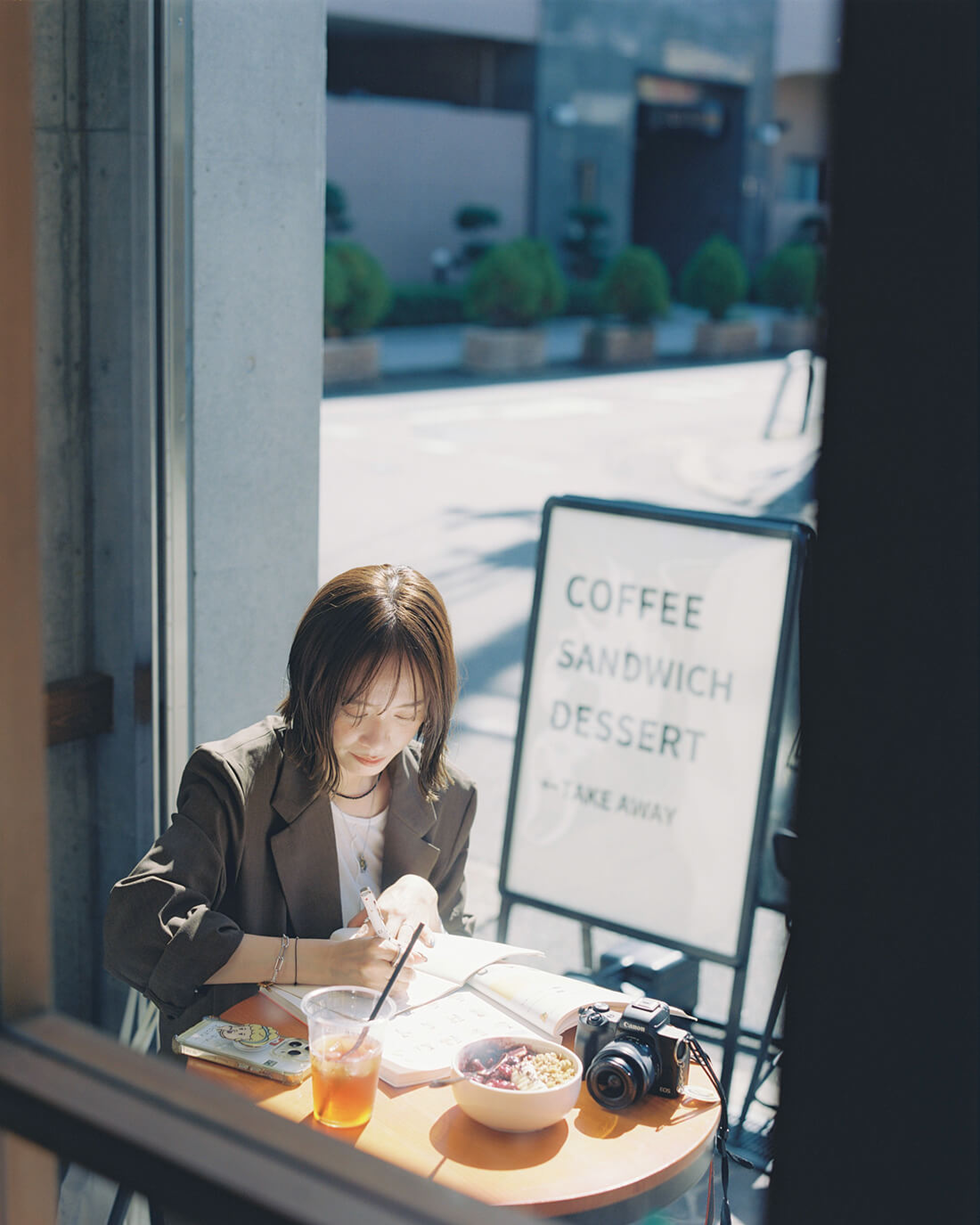 窓際の席でノートに向かうShiori