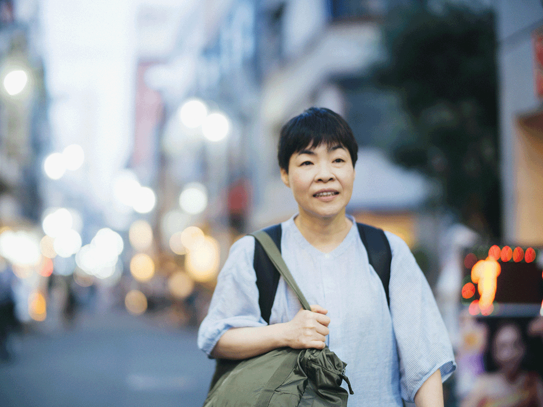 劇場を後にした山田花子さんが、夕暮れの街を歩いている。
